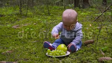 婴儿是婴儿坐在森林里吃大苹果